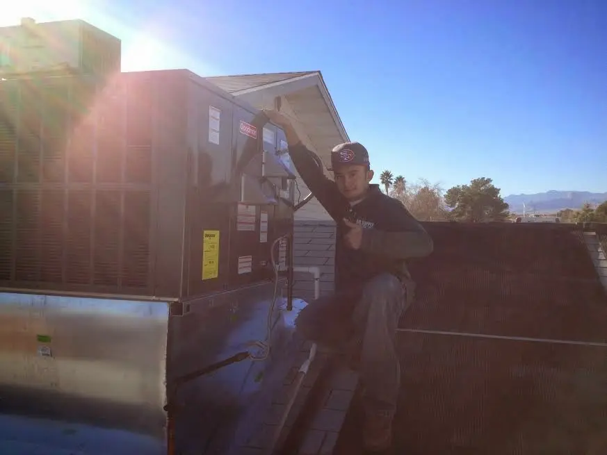 HVAC technician performing AC Tune-Up on a rooftop unit in Golden Hills